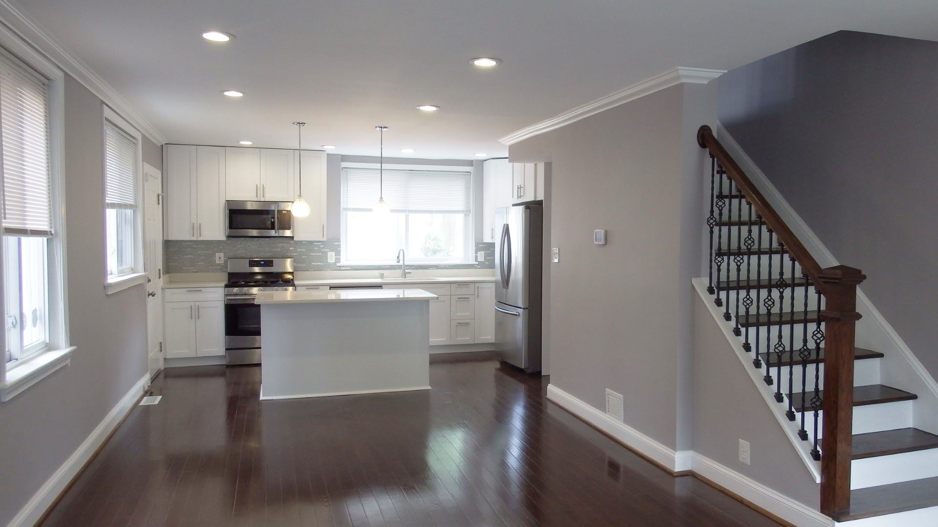 Open kitchen with island and staircase after renovation